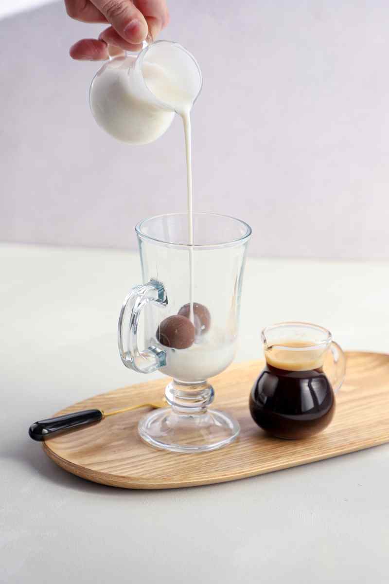Café Bombón de Bonafide con tres bombones rellenos de dulce de leche, acompañado de un shot de espresso y leche caliente cremosa